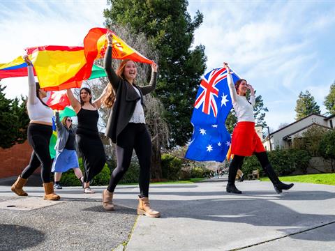 a group of college students waving international flags