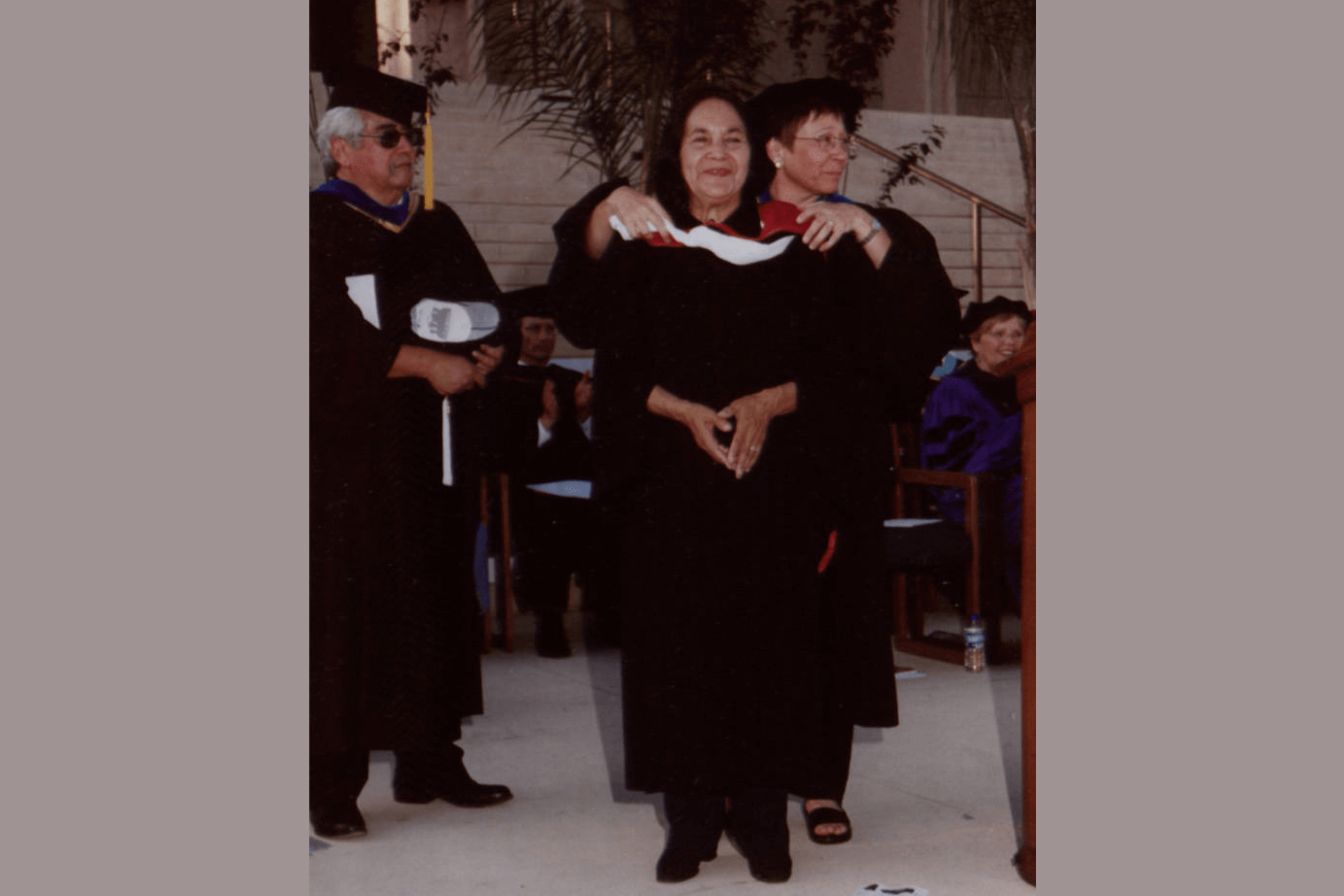 a woman being hooded at an honorary degree ceremony