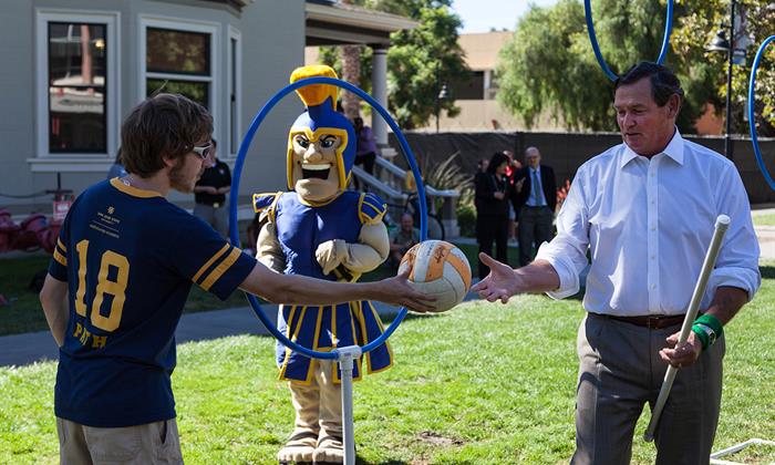 Chancellor White hands a ball to a quidditch from San José State