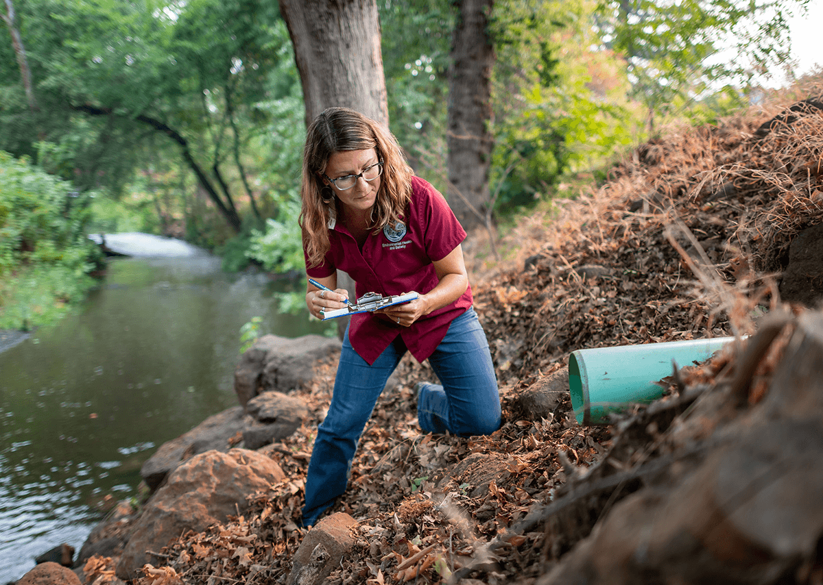 Industrial Hygienist & Environmental Program Manager Holly Swan checks creek out flows.
