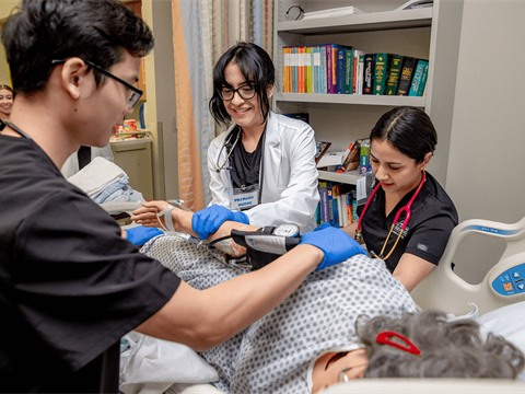 Cal State San Bernardino nursing students checking on practice patient's vitals.