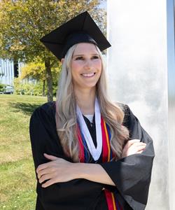 A woman wearing a graduation cap and gown.