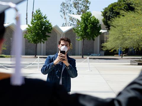 man taking photo of a college graduate 