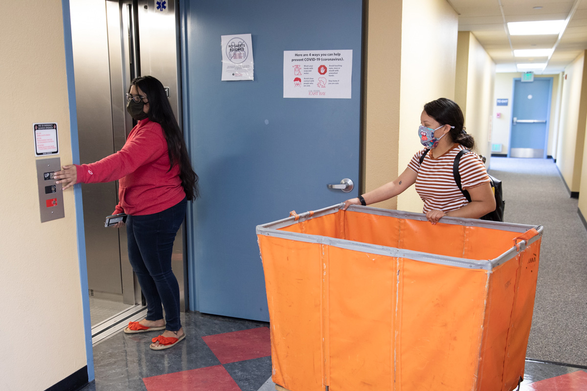 CSUEB resident assistant Arsheep Sidhu, left, prepares for move-in day with residence life professional Gisela Ramirez.