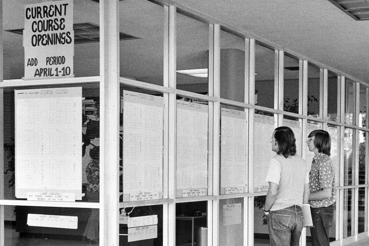 Students looking at a list of add/drop classes in a window of the Administration Building at Cal Poly Pomona in spring of 1974.
