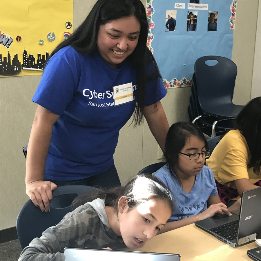 San José State Civic Action Fellowship Program Coordinator Joanna Solis working with two girls through the Cyber Spartans progra