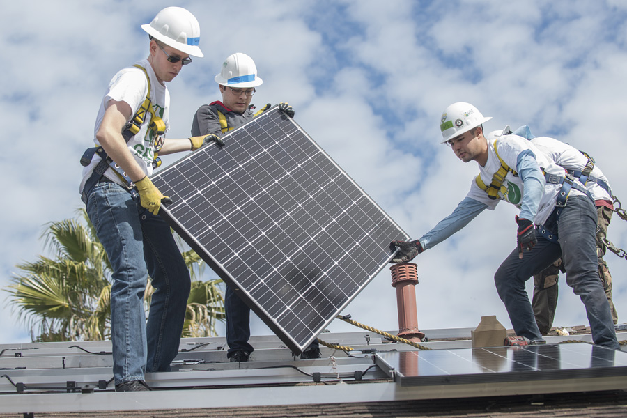 Cal Poly Pomona electrical engineering majors Johnny Bautista (center) and Sean McClanahan (left) assist Grid Alternative worker Miguel Rodarte, March 20, 2018. The students volunteered to set up solar panels for low-income families during spring break.