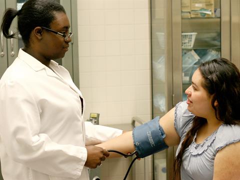 healthcare student checking blood pressure of patient