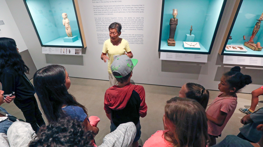 A Robert and Frances Fullerton Museum of Art docent gives local students a tour of the Egyptian collection.