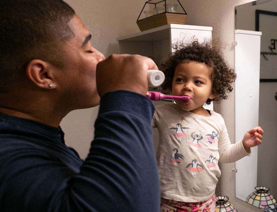 Steven and his daughter brushing their teeth.
