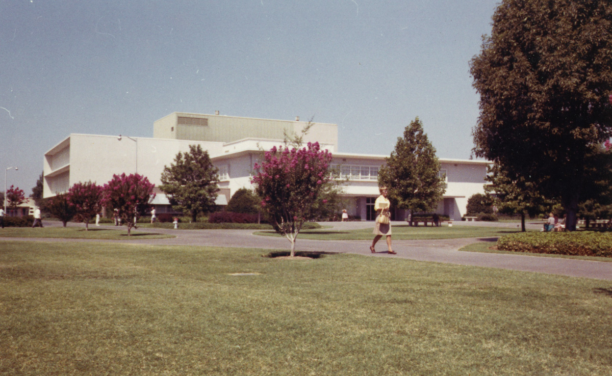 A student strolls by the Old Library building (currently Lassen Hall) on her way to class, 1964.